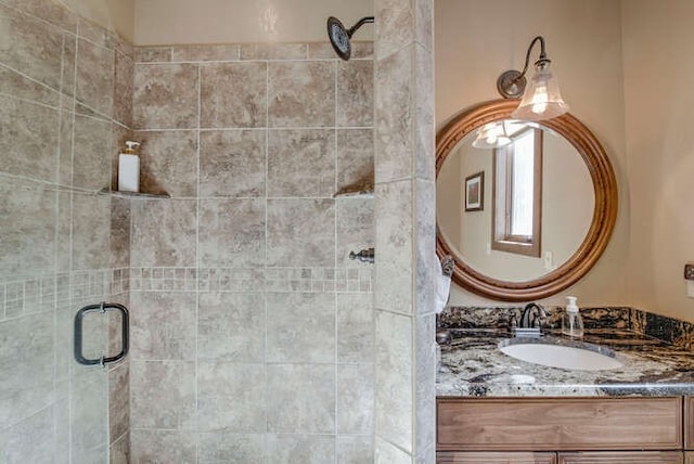 bathroom featuring vanity and a shower with door