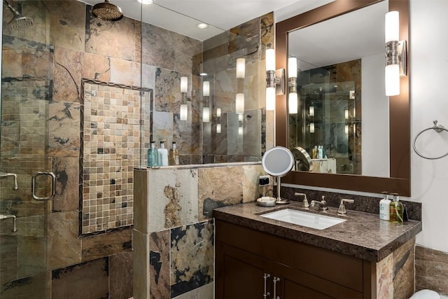 bathroom with vanity, a shower with shower door, and tile walls