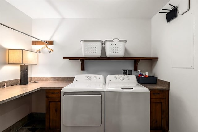 clothes washing area with cabinets and washing machine and clothes dryer