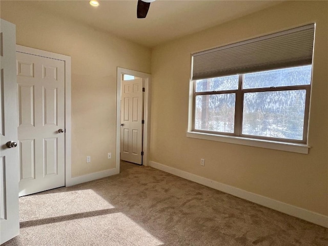 unfurnished bedroom with ceiling fan and light carpet