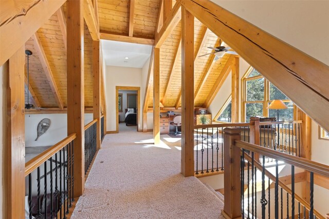 hall featuring carpet flooring, lofted ceiling with beams, and wooden ceiling