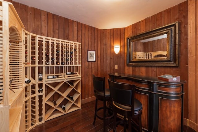 wine cellar featuring dark hardwood / wood-style floors and wood walls