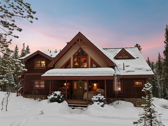 snow covered property with a porch