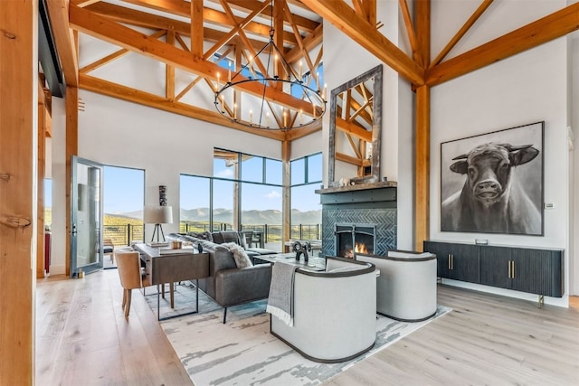 living room featuring a mountain view, hardwood / wood-style floors, an inviting chandelier, and high vaulted ceiling