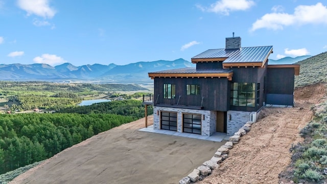 rear view of property featuring a mountain view and a garage