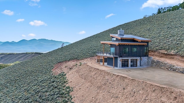 exterior space featuring a deck with mountain view, a patio, and a garage