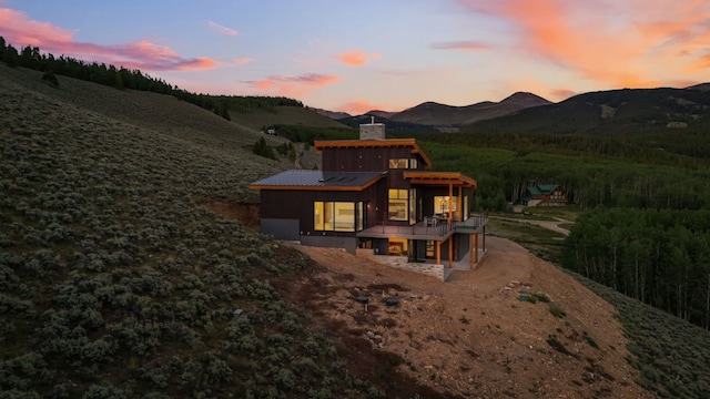 back house at dusk featuring a deck with mountain view