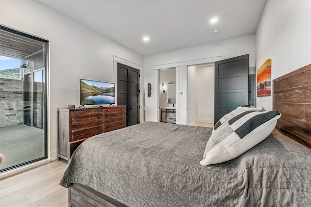 bedroom with access to exterior and light hardwood / wood-style flooring