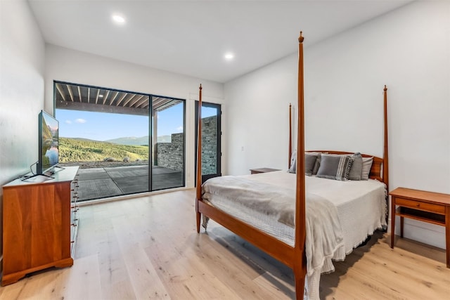 bedroom with access to exterior and light hardwood / wood-style flooring