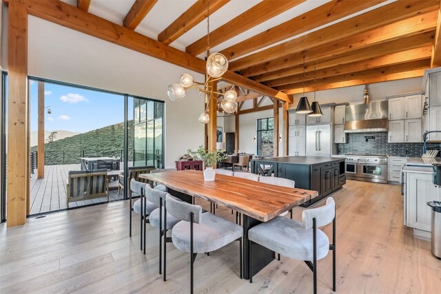 dining space featuring beam ceiling, light hardwood / wood-style flooring, and a notable chandelier