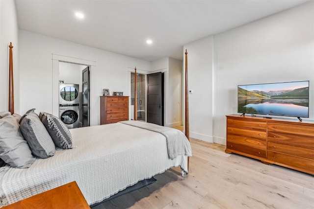 bedroom with light hardwood / wood-style flooring and stacked washing maching and dryer