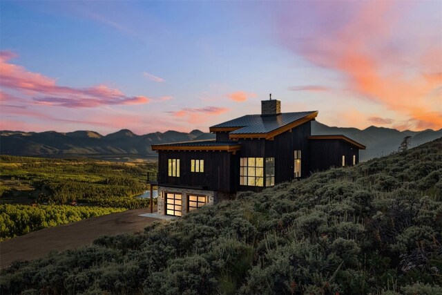 property exterior at dusk featuring a mountain view and a garage