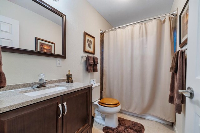 bathroom with tile patterned flooring, vanity, and toilet