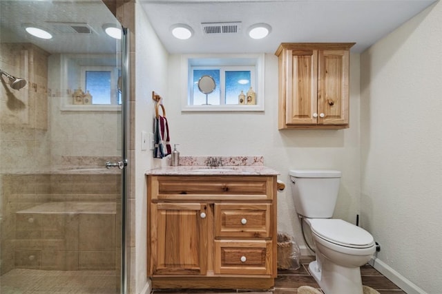 bathroom with walk in shower, hardwood / wood-style flooring, vanity, and toilet