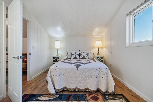 bedroom featuring wood walls and hardwood / wood-style flooring