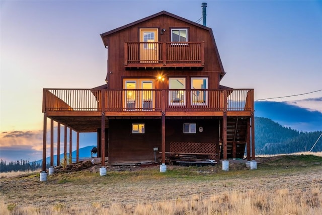 back house at dusk with a deck