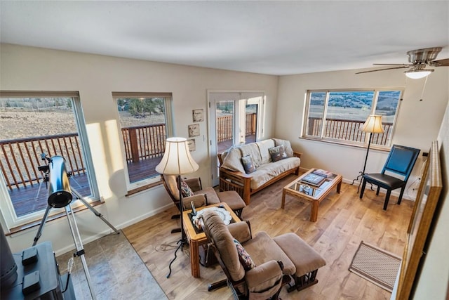 living room with ceiling fan and light hardwood / wood-style flooring