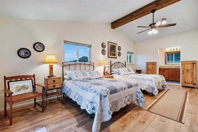 bedroom featuring vaulted ceiling with beams, ceiling fan, light wood-type flooring, and ensuite bathroom