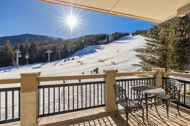 snow covered deck with a mountain view