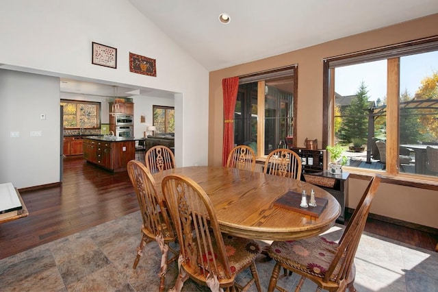 dining area featuring dark hardwood / wood-style flooring and high vaulted ceiling