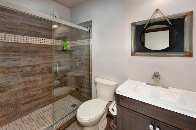 bathroom featuring an enclosed shower, vanity, and toilet