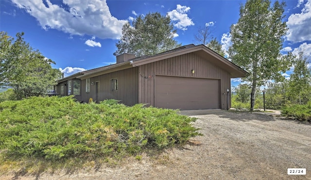 view of property exterior with a garage and dirt driveway