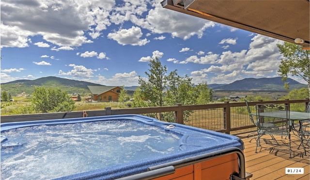 exterior space with outdoor dining space, a mountain view, and a hot tub