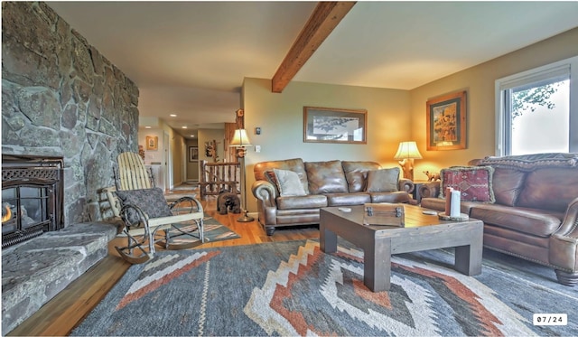 living area featuring beam ceiling and wood finished floors