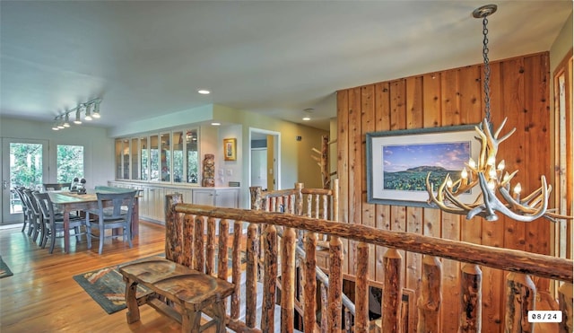 interior space with a notable chandelier, rail lighting, and wood finished floors