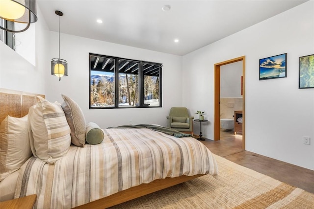 bedroom with connected bathroom and concrete flooring