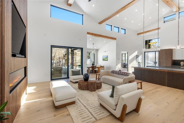 living room featuring beam ceiling, a fireplace, plenty of natural light, and high vaulted ceiling