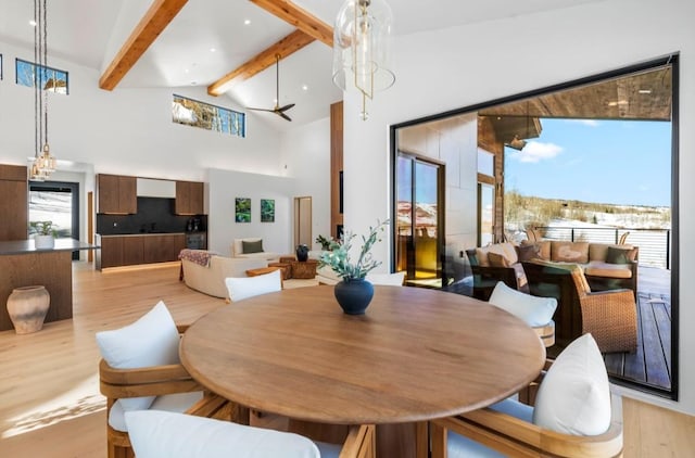 dining room with beam ceiling, ceiling fan, high vaulted ceiling, and light hardwood / wood-style floors