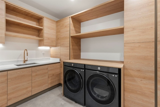 washroom with washer and clothes dryer, cabinets, and sink