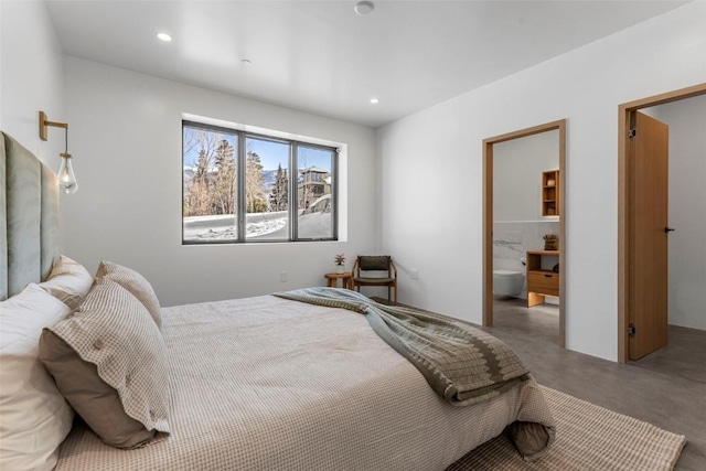 bedroom featuring concrete flooring and connected bathroom