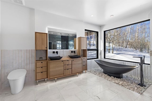 bathroom featuring vanity and tile walls