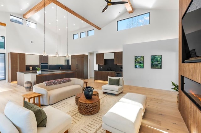 living room featuring beamed ceiling, ceiling fan, high vaulted ceiling, and light hardwood / wood-style flooring