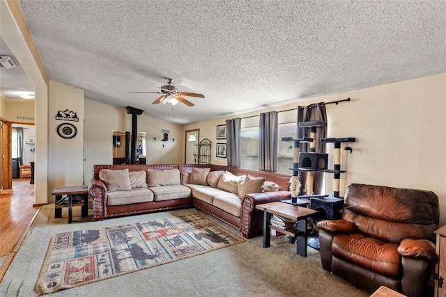 living room with ceiling fan, carpet floors, and a textured ceiling