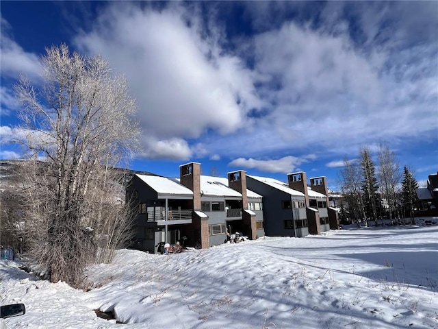 view of snow covered rear of property