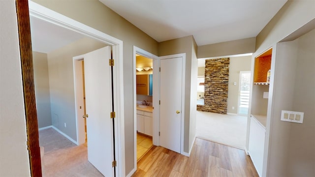 hall featuring sink and light carpet