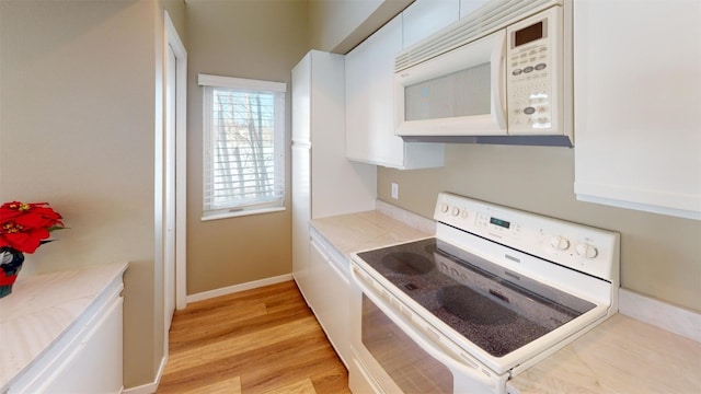 kitchen featuring light hardwood / wood-style flooring, white cabinets, and white appliances