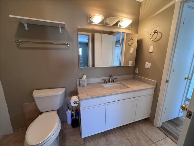 bathroom featuring tile patterned flooring, vanity, and toilet