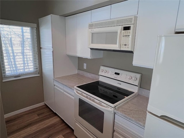 kitchen with white cabinets, dark hardwood / wood-style flooring, and white appliances