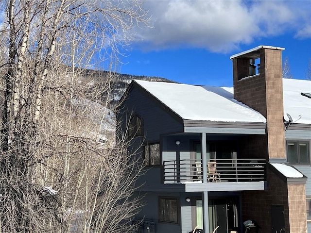 snow covered property featuring a balcony