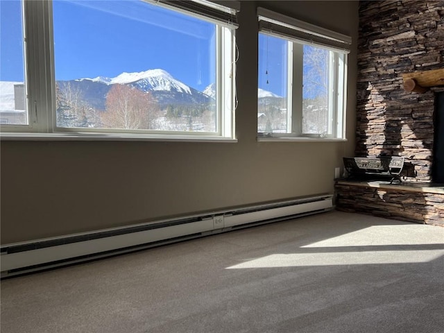 spare room featuring carpet flooring, a mountain view, and a baseboard heating unit