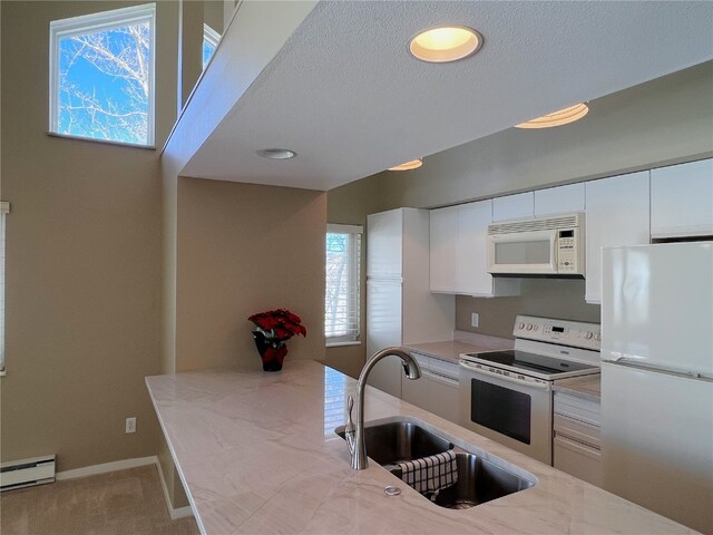 kitchen featuring carpet flooring, white appliances, sink, a baseboard radiator, and white cabinets