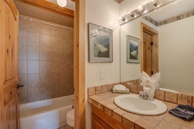 full bathroom featuring vanity, tiled shower / bath combo, and toilet