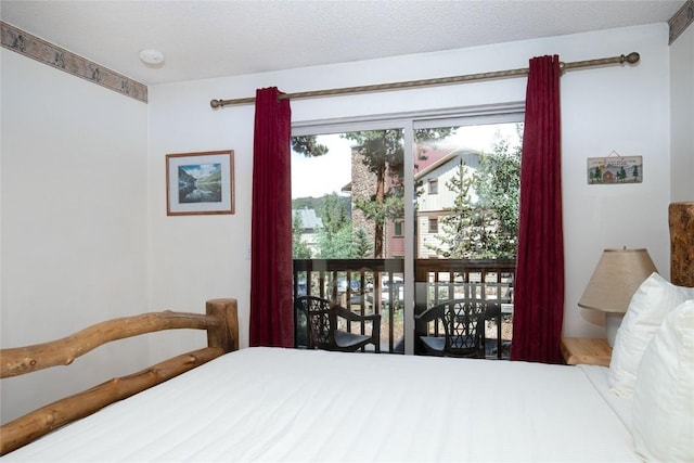 bedroom with a textured ceiling and access to outside