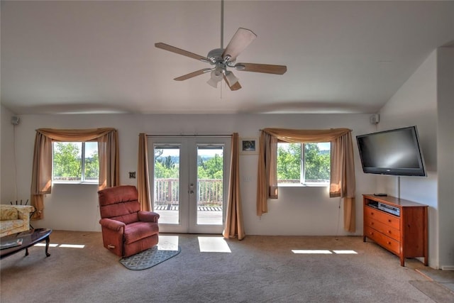 sitting room with ceiling fan, vaulted ceiling, light colored carpet, and french doors