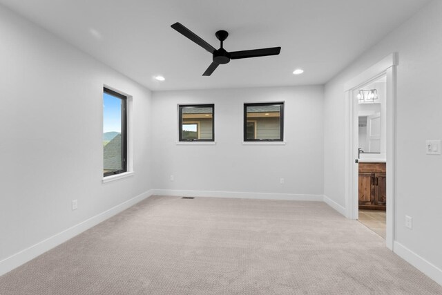 spare room with light carpet and ceiling fan