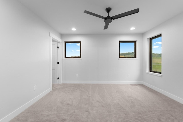 spare room with ceiling fan and light colored carpet